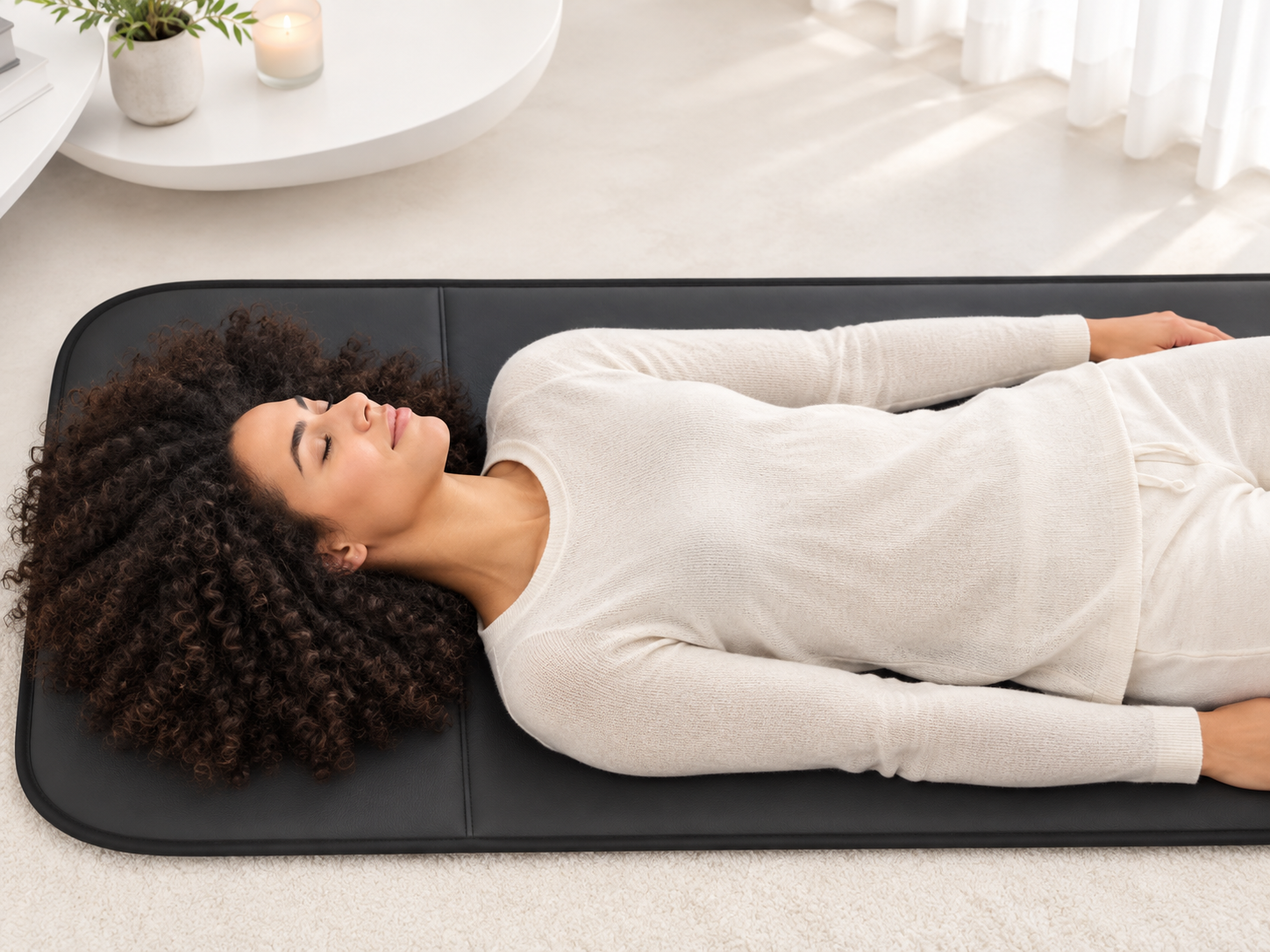 Woman relaxing on a BEMER mat at home